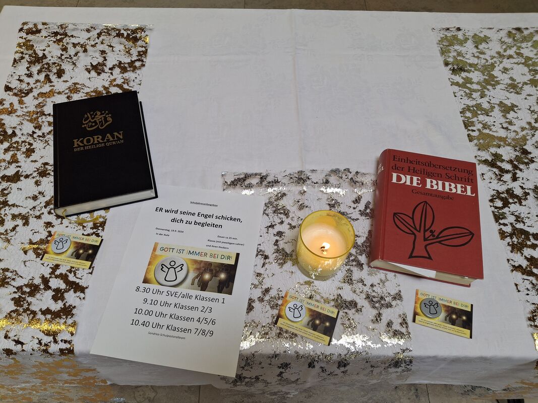 Bibel und Koran liegen auf einem Tisch mit Sprüchen und brennender Kerze