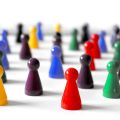 Viele Spielfiguren stehen neben- und hintereinander auf weißem Untergrund
