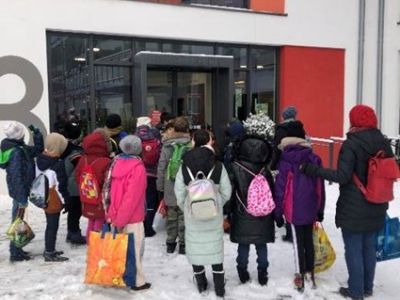 Schüler stehen im Schnee vor der Stadtbücherei